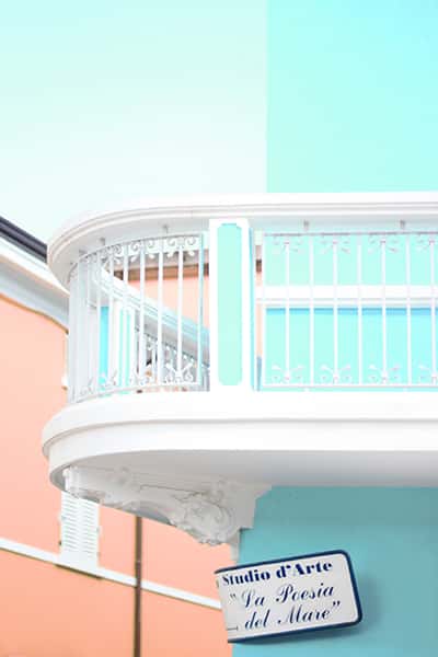 Balkon an einer türkisen Wand mit Gitter Mustern