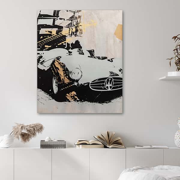Ein alter Maserati in gold, weiß und schwarz in einem Raummilieu