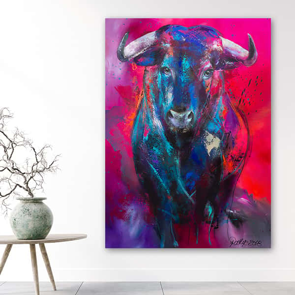 Ein Stier mit Hörnern vor einem knallroten Hintergrund in einem Raummilieu