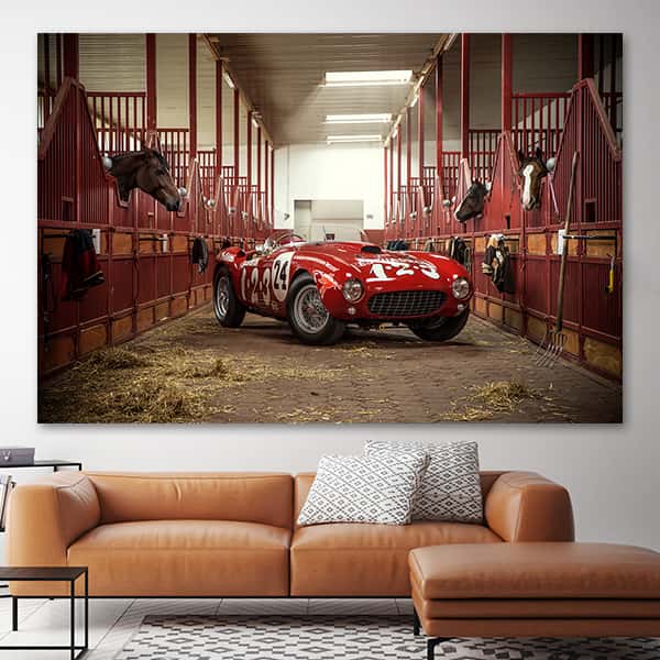 Ein roter Ferrari 375 MM Spider Pinifarina im Gang eines Pferdestalls in einem Raummilieu