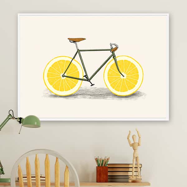 Ein sportliches Fahrrad mit Zitronenscheiben als Räder in einem weißen Schattenfugenrahmen in einem Raummilieu