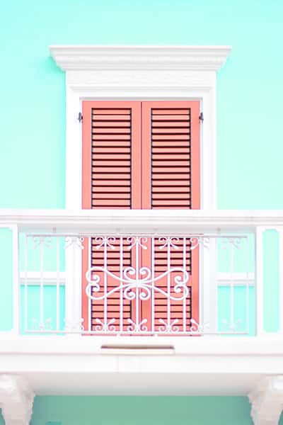 Ein romantischer Balkon mit einer roten Holztür