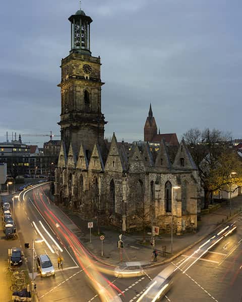 Die Agedienkirche in Hannover bei grauen Wolken und Lichtstreifen am Boden