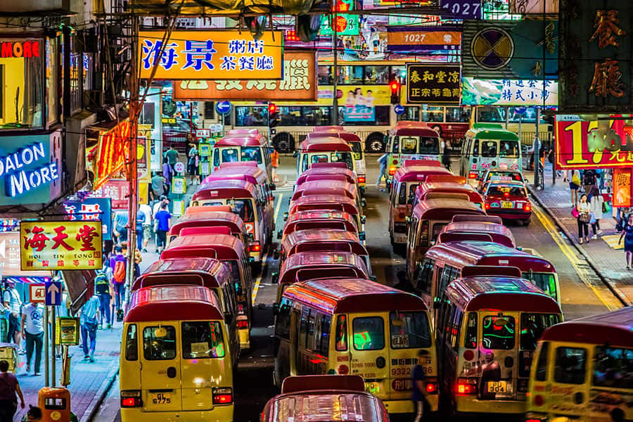 Eine volle Straße mit bunter Werbung in Mongkok Kowloon
