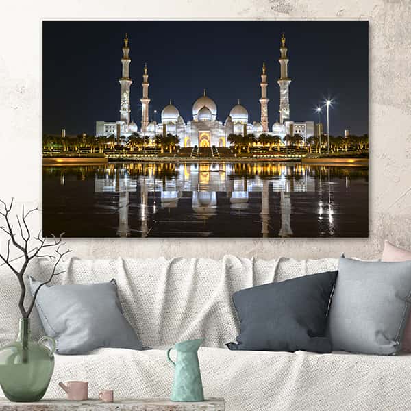 Die Scheich-Zayid-Moschee in Abu Dhabi spiegelt sich bei Nacht im Wasser in einem Raummilieu