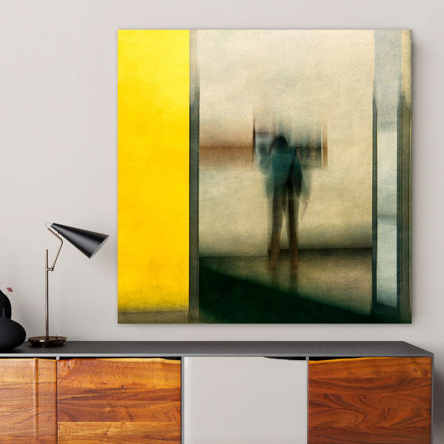 Eine Person steht vor einer beigen Wand und schaut sich ein Gemälde an in einem Raummilieu