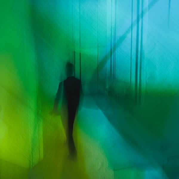 Im grün-bläulichen Licht eines Ganges ist die Silhouette eines Menschen zu erkennen