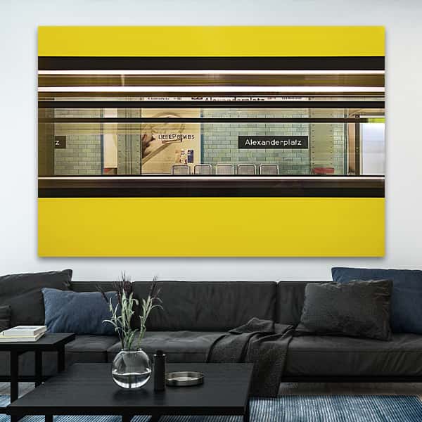 Blick durch eine gelbe U-Bahn an der Haltestelle Alexanderplatz in einem Raummilieu