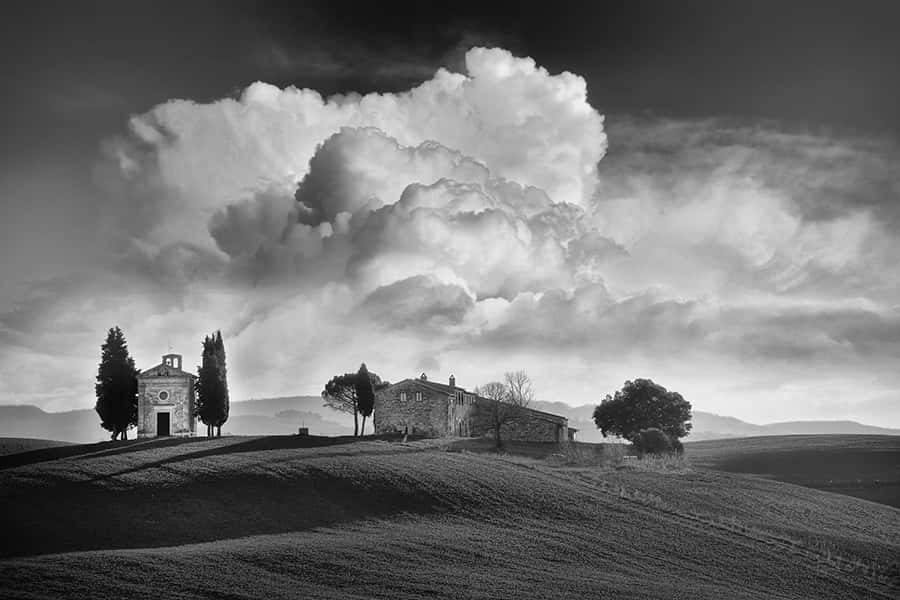 Ein schwarzweiß Bild von einem Dorf mit einer riesigen Wolke