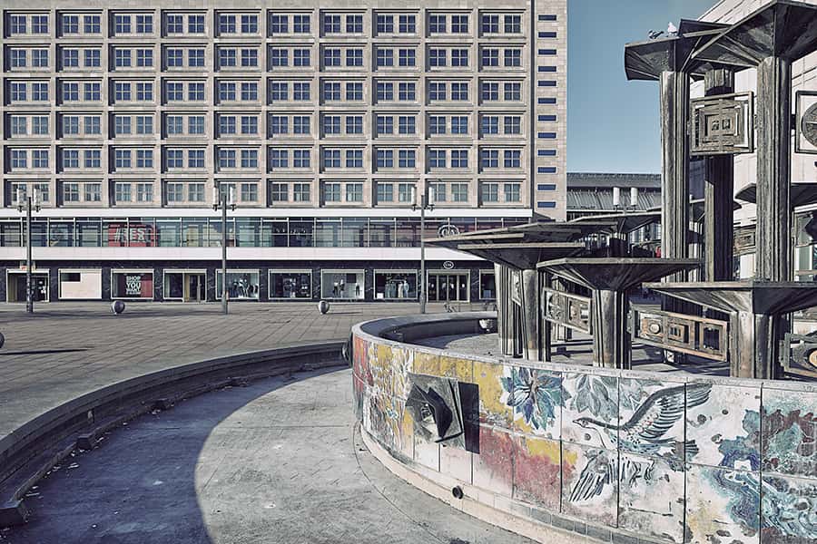 Trockener Brunnen mit Graffiti und einem grauen Gebäude in Berlin