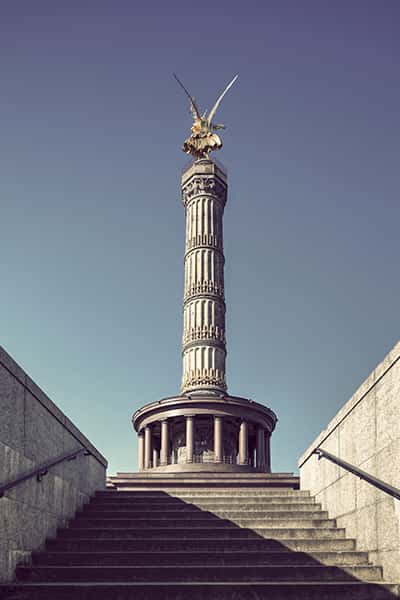 Blick von unten auf das Denkmal Siegessäule in Berlin vor blauem Himmel