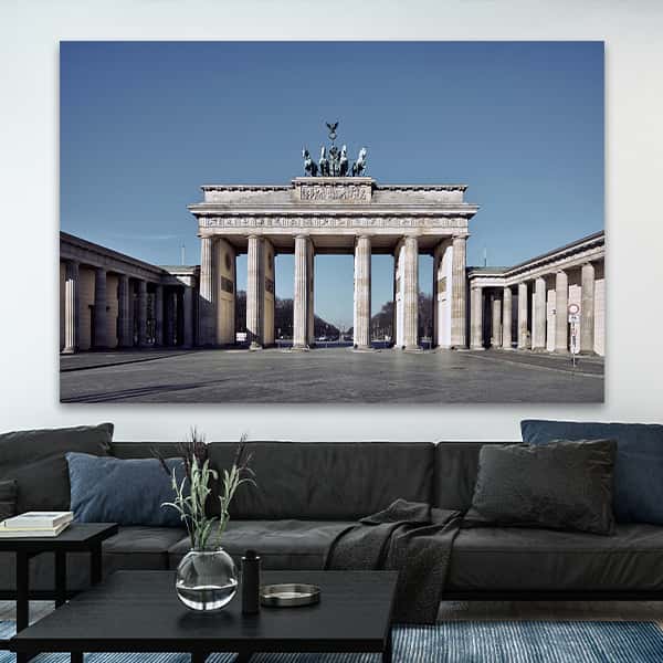 Das Brandenburger Tor in Berlin bei blauem Himmel und Sonne in einem Raummilieu