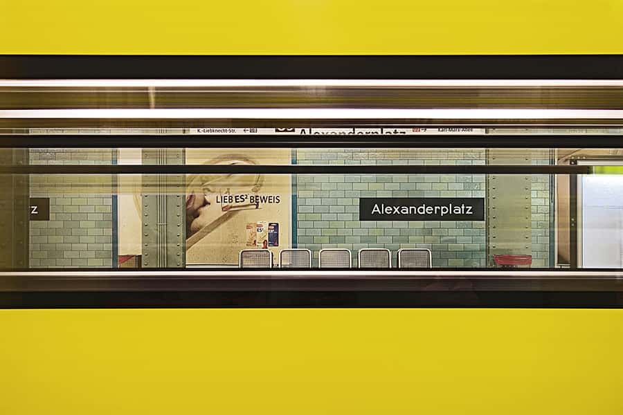 Blick durch eine gelbe U-Bahn an der Haltestelle Alexanderplatz 