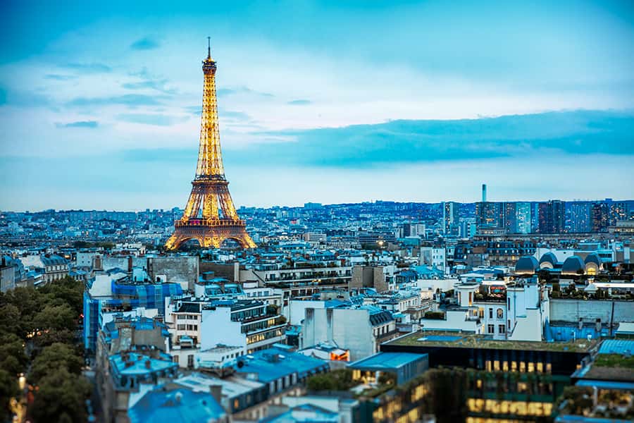 Eiffelturm in Paris umgeben von mehreren Gebäuden und ein blauer Schimmer