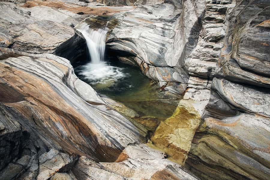 Gebiet mit großen graubraunen Felsen zudem ein Wasserfall in der Mitte
