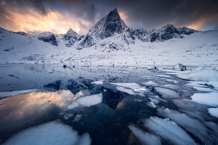 Der Blick auf einen vereisten See in den verschneiten Bergen