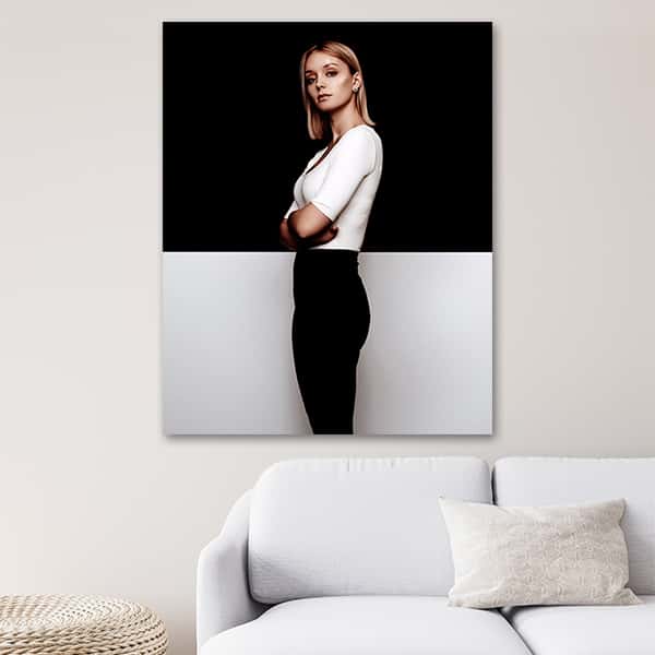 Eine Frau in Schwarz weißer Kleidung steht vor einer schwarz weißen Wand  in einem Raummilieu