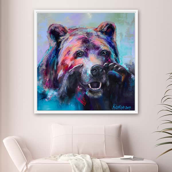 Der Kopf eines Bären mit erhobenen Tatzen in blau und rot Tönen in einem weißen Schattenfugenrahmen in einem Raummilieu