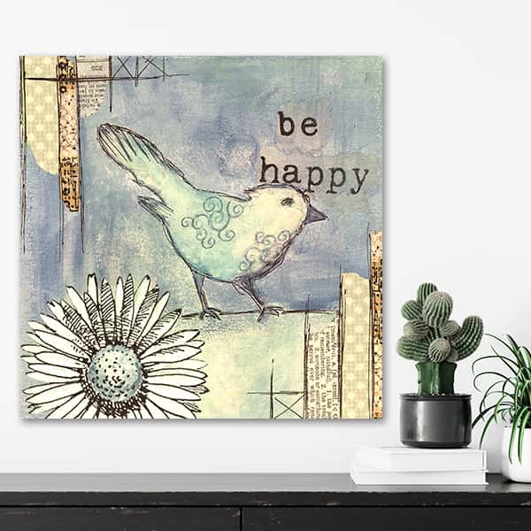 Ein Vogel und eine Blume und ein Schriftzug mit be happy in einem Raummilieu