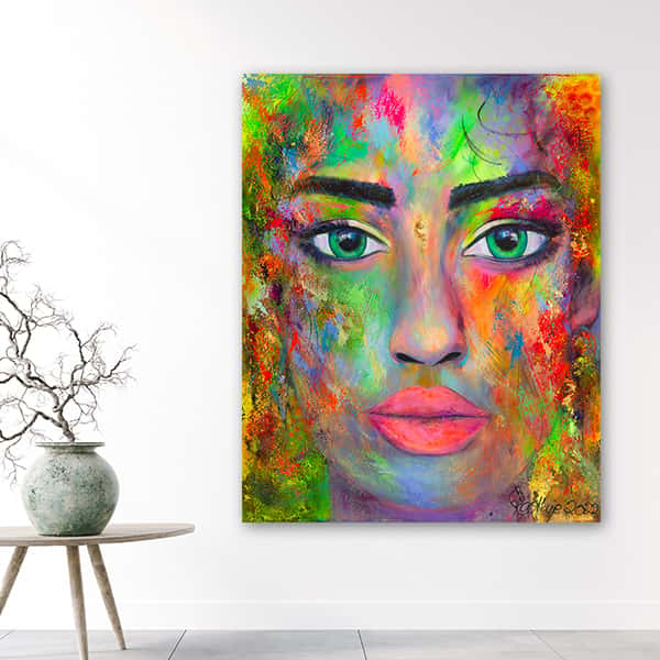 Das Gesicht einer Frau überdeckt mit bunten Holi Farben in einem Raummilieu