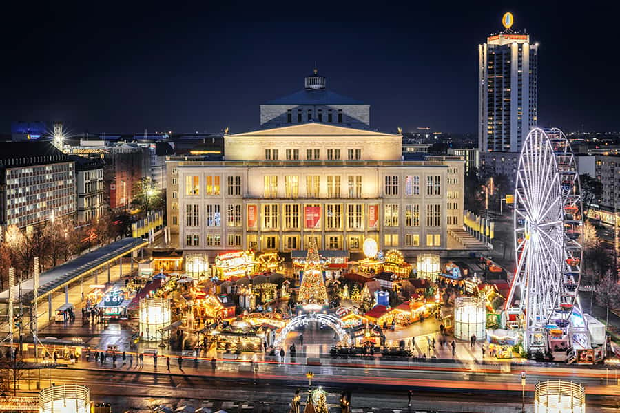 Der Weihnachtsmarkt mit einem Riesenrad stark beleuchtet in Leipzig