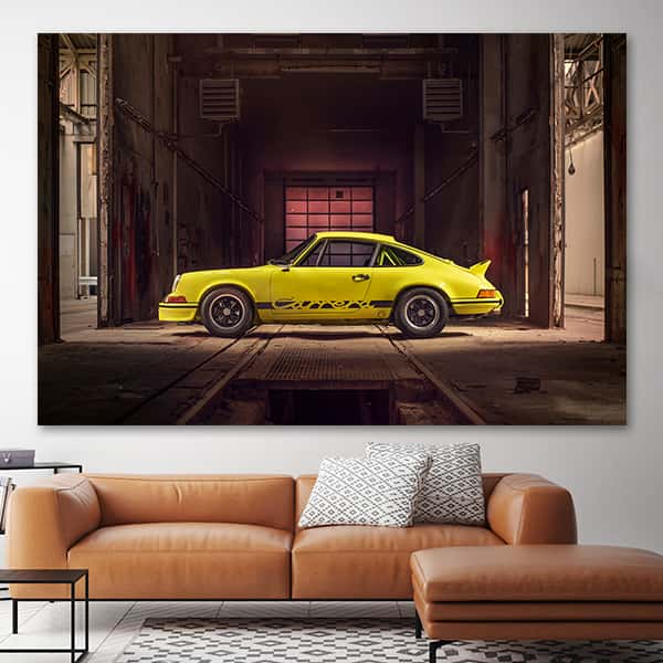 Seitenansicht eines gelben Porsche 911 Carrera RS 2.7 in alter Industriehalle in einem Raummilieu